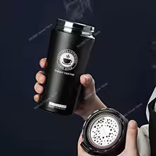 Clarify.pk black vacuum insulated coffee thermos flask held in hand with steam rising from lid
