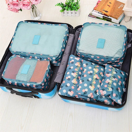 6 piece luggage organizer set with floral pattern neatly packed inside an open blue suitcase