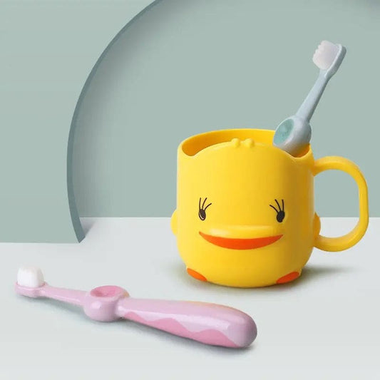 Cute duck toothbrush cup in yellow holding a toothbrush with a pink toothbrush beside it