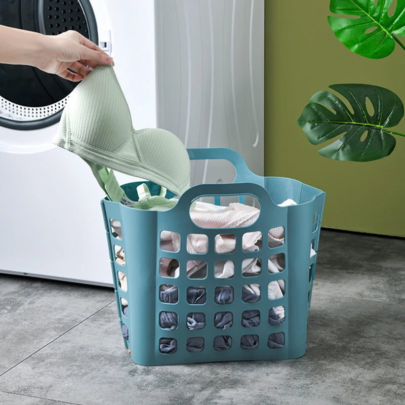Blue foldable plastic laundry basket filled with clothes next to washing machine in laundry room