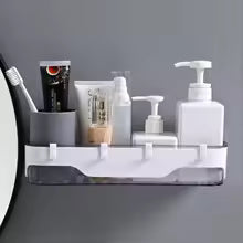 Wall-mounted bathroom shelf by Clarify.pk holding toothbrushes, toothpaste, and liquid soap dispensers