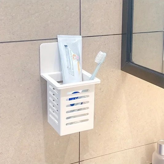 White wall mounted organizer holding a toothbrush and toothpaste attached to tiled bathroom wall
