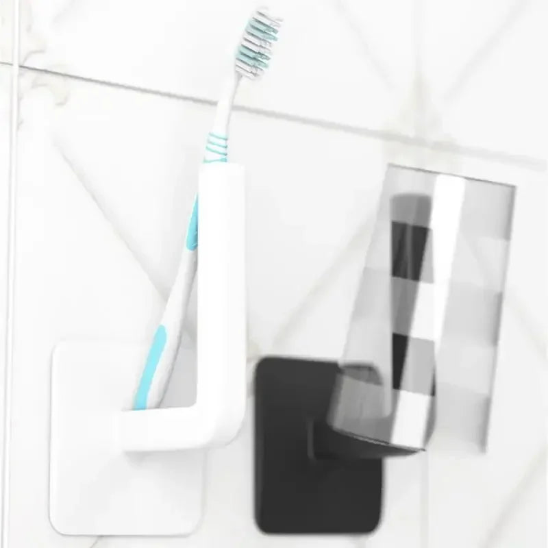 Wall mounted paper towel holder and toothbrush holder in white and black on tiled bathroom wall