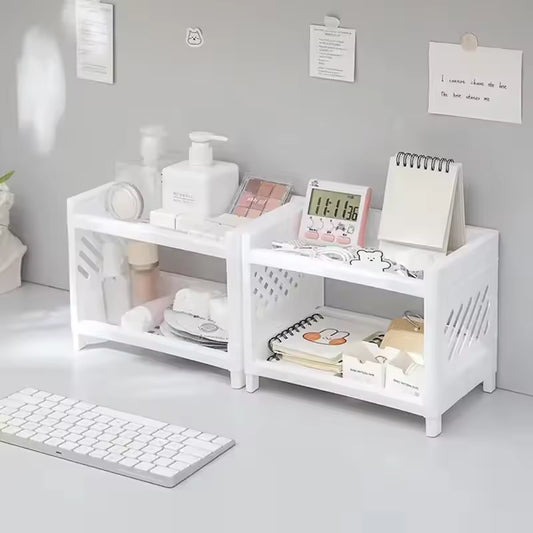 White double layer desk organizer holding cosmetics, a digital clock, notepad, and stationery on a gray desk