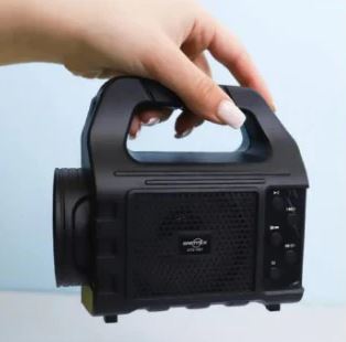 Wireless portable speaker with radio in black featuring a handle and control buttons held by a hand