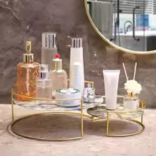 Elegant wrought iron storage rack with gold finish holding beauty and skincare products on a marble countertop
