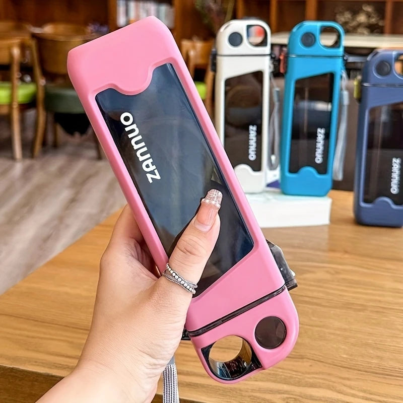Hand holding pink 350ml sports water bottle with black window and brand name on wooden table