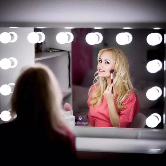 Blonde woman applying makeup in front of a mirror with a 10 bulb vanity light set from Clarify.pk