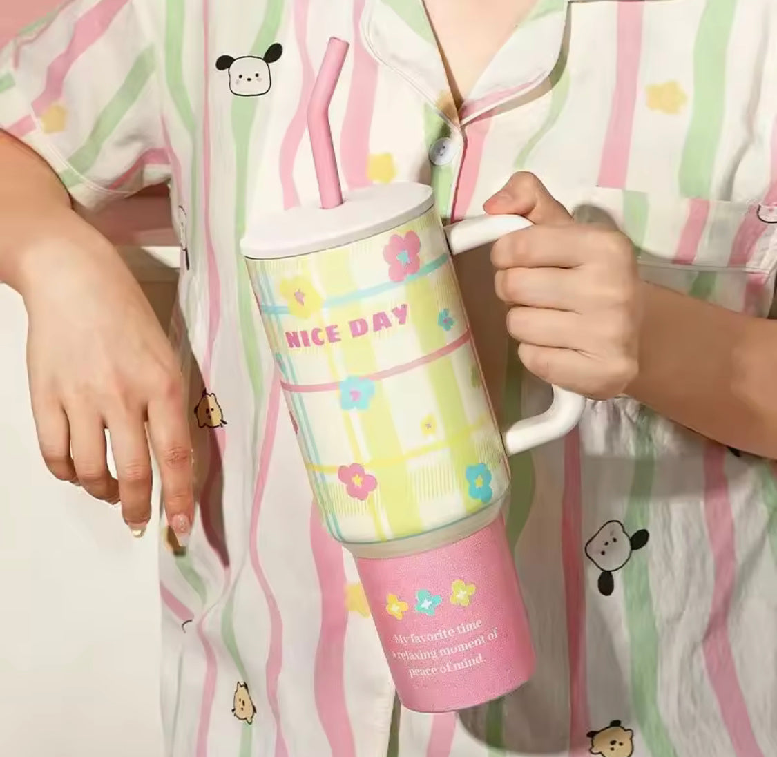 1200ml stainless steel tumbler with floral pattern and pink base held by person in striped pajamas