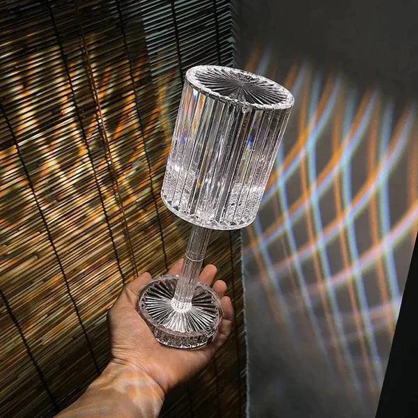 Hand holding a clear crystal 16 colors diamond lamp casting colorful light patterns on walls