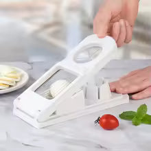 2 in 1 multifunctional kitchen tool slicing white vegetable on countertop with tomatoes and herbs
