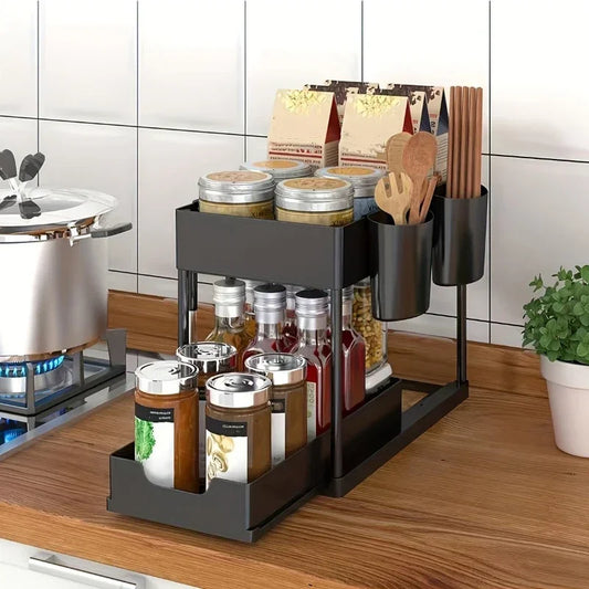2 tier kitchen organizer in black holding jars, bottles, and utensils on wooden countertop