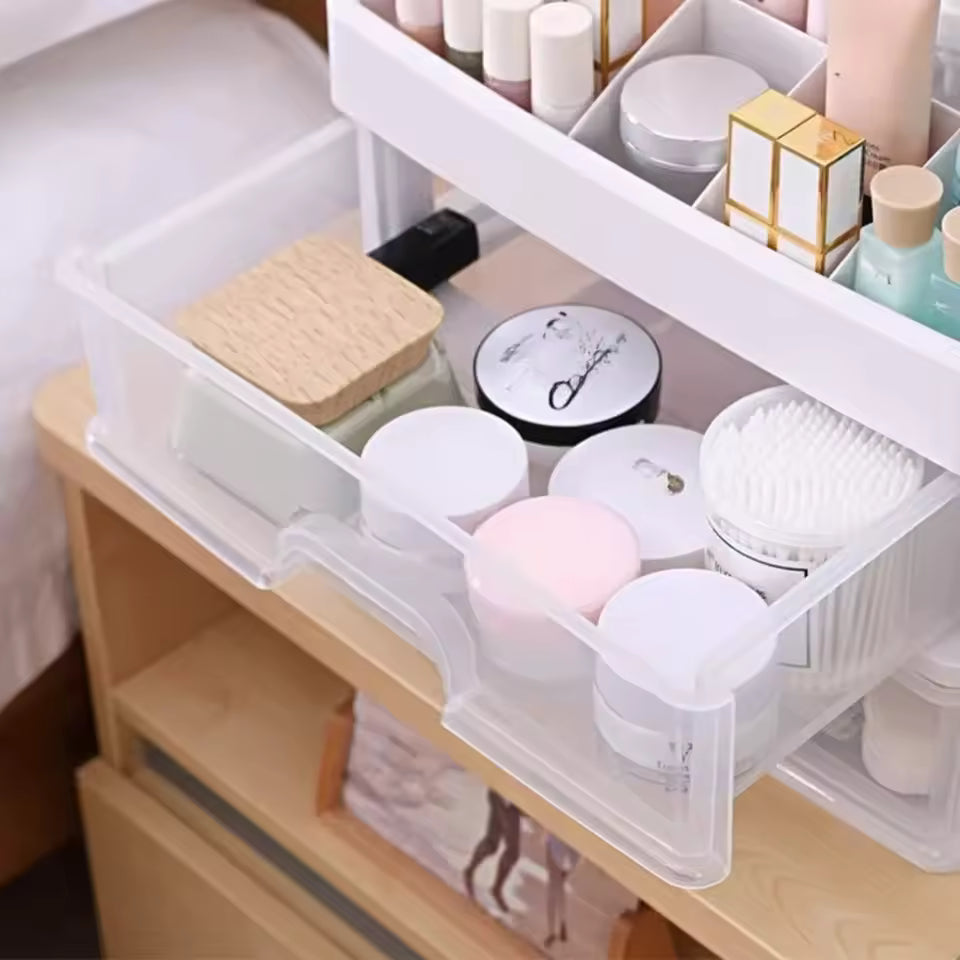 Clear 3 layer cosmetic storage case holding various beauty products on a wooden surface