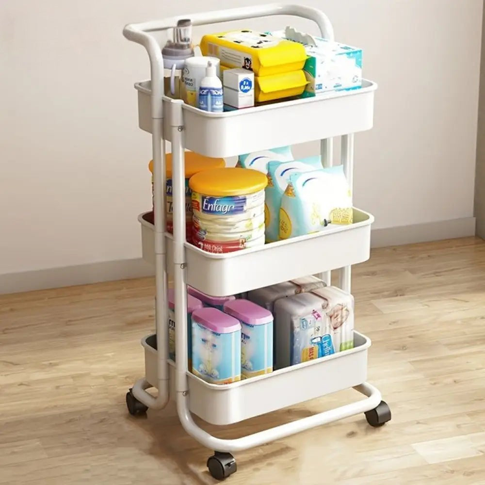 3 tier folding metal cart with wheels in white holding various household items on wooden floor