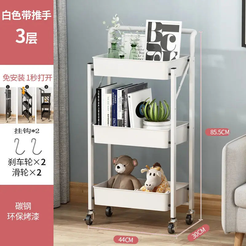 White 3 tier folding metal cart with wheels holding books, plants, and toys in living room
