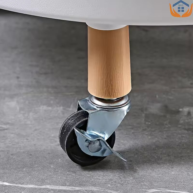 Close-up of a black caster wheel attached to wooden leg of a 3 tier rotating cart in home furniture