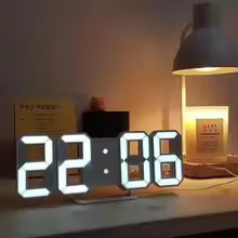 Clarify.pk 3D LED digital wall clock displaying time 22:06 on a desk with lamp and books