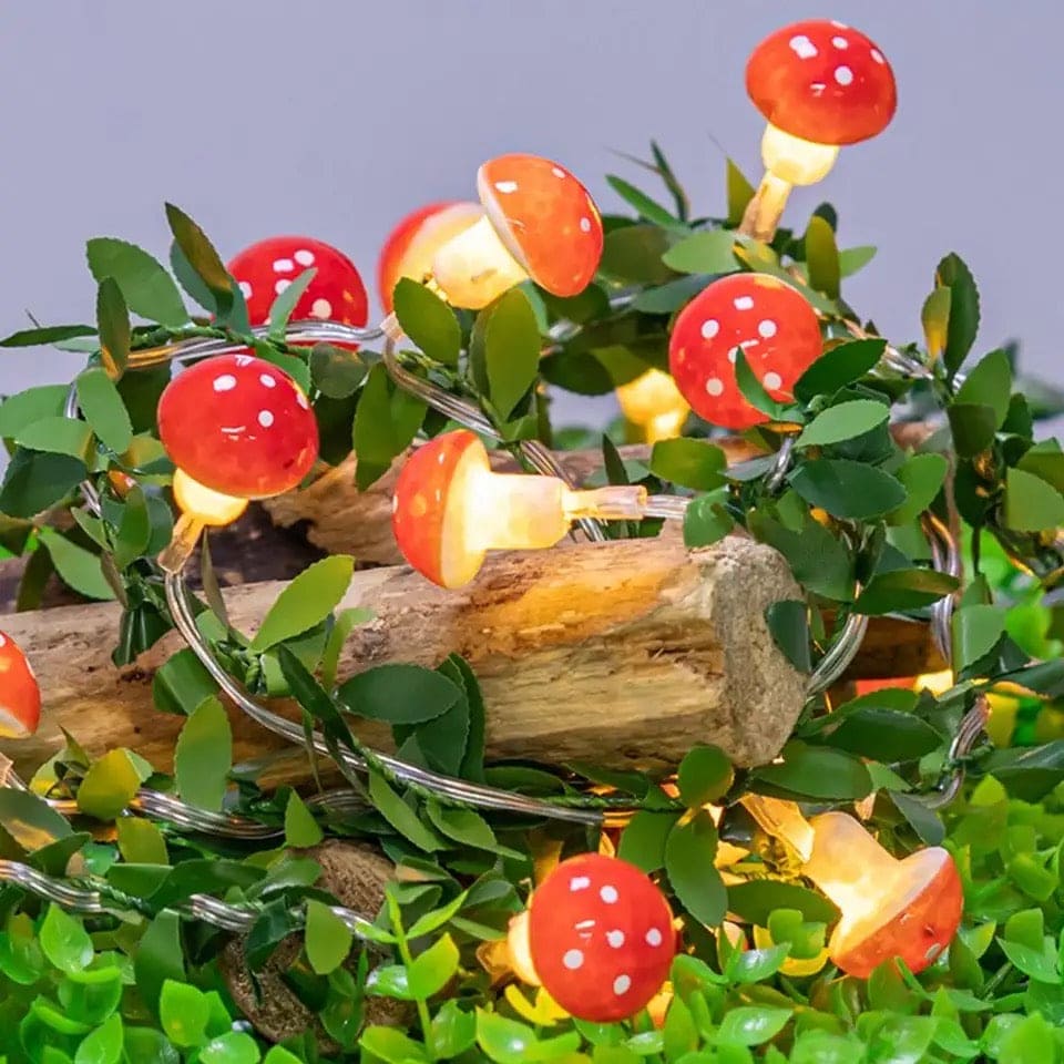 Clarify.pk 3D mushroom string lights with glowing red mushroom caps and white dots wrapped around greenery