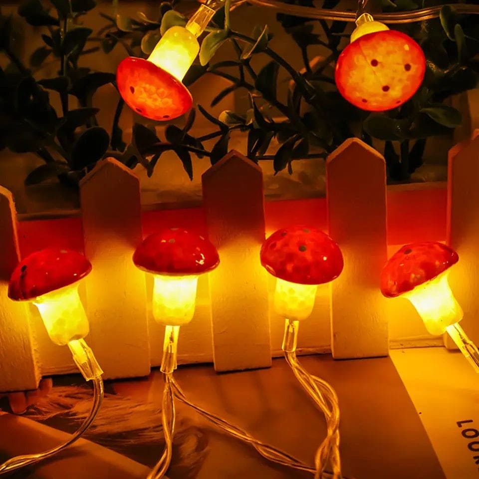 Warm glowing 3D mushroom string lights with red caps hanging in cozy indoor decor