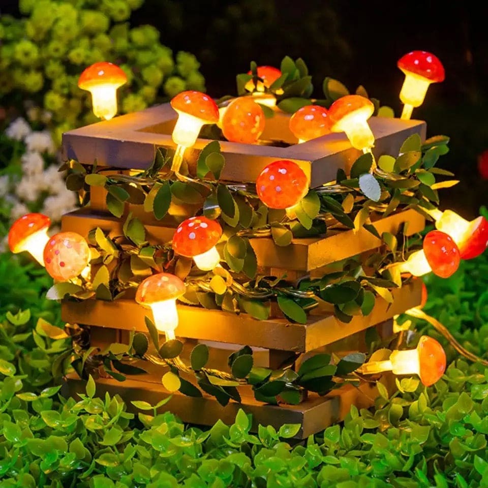 3D mushroom string lights glowing orange and white wrapped around a wooden cube with green leaves at night