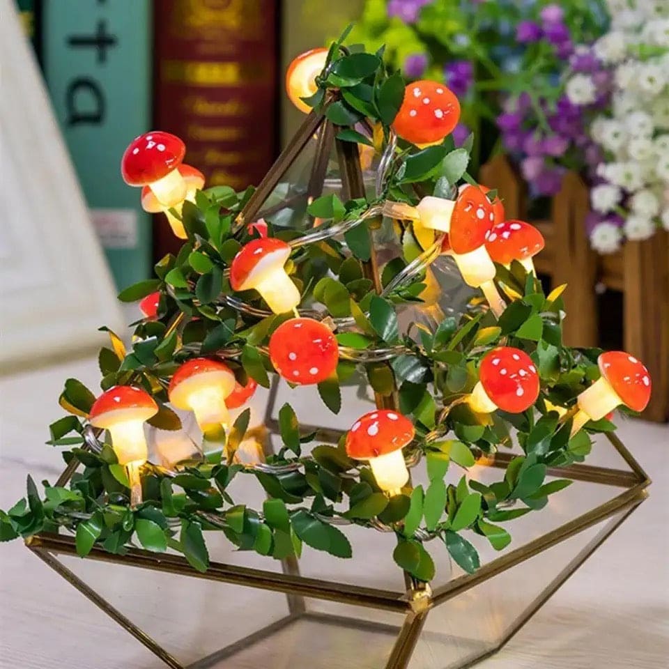 3D mushroom string lights with red caps and white stems arranged in a decorative plant display