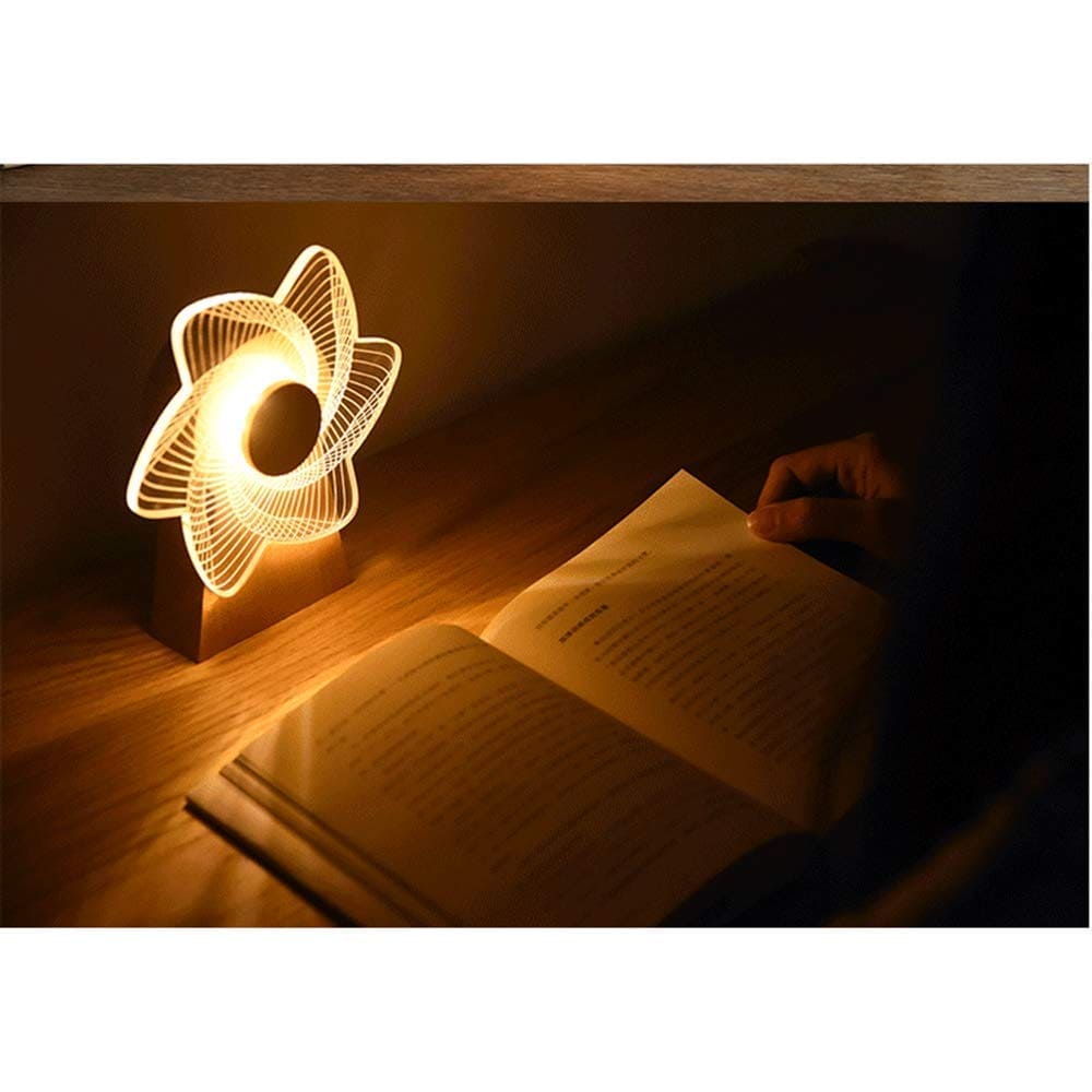 Clarify.pk 3D windmill night light lamp glowing warm yellow light next to an open book on wooden table