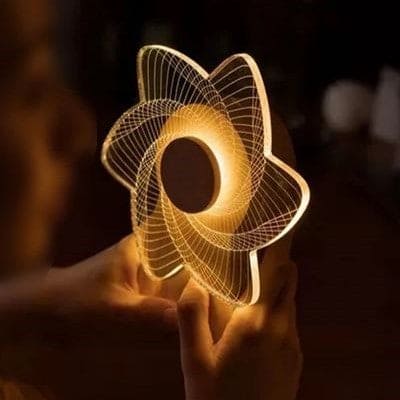 3D windmill night light lamp glowing warm yellow held in hands in a dark room