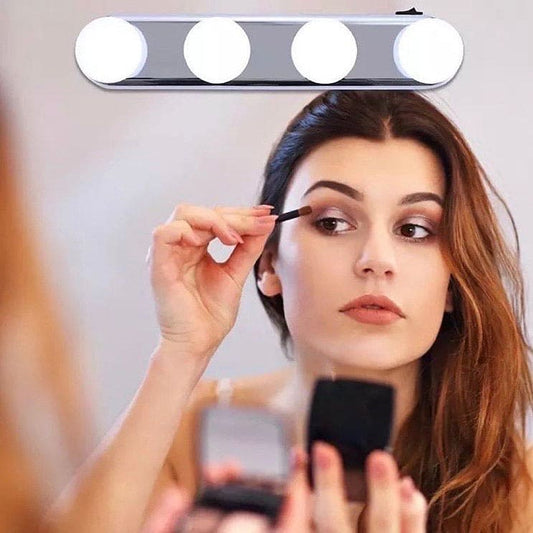 Woman applying makeup using a 4 bulb makeup mirror light mounted above her mirror