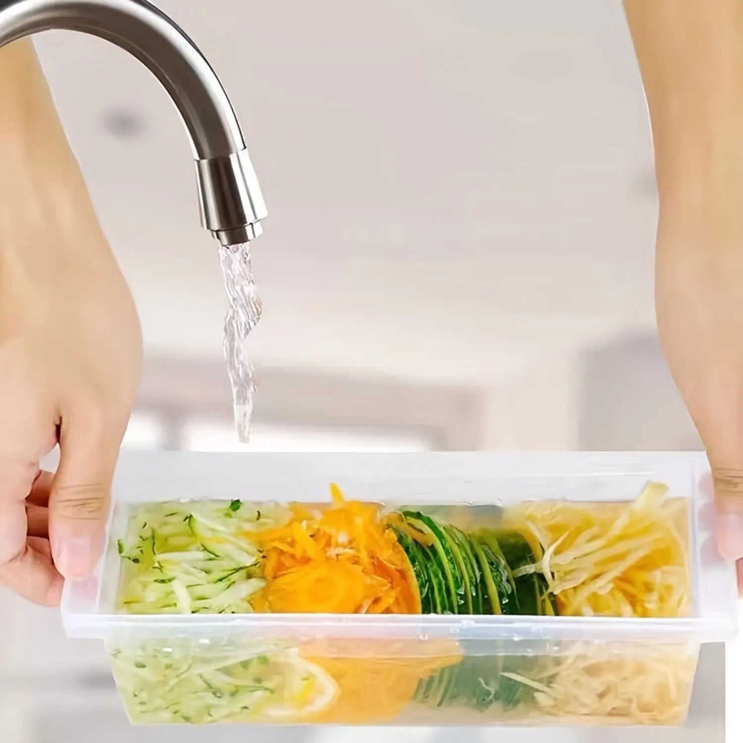 5-in-1 kitchen slicer for vegetables with multiple sliced vegetables in a clear container under running water