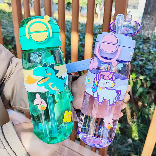 600ml kids water bottle with straw featuring colorful dinosaur and unicorn designs held outdoors