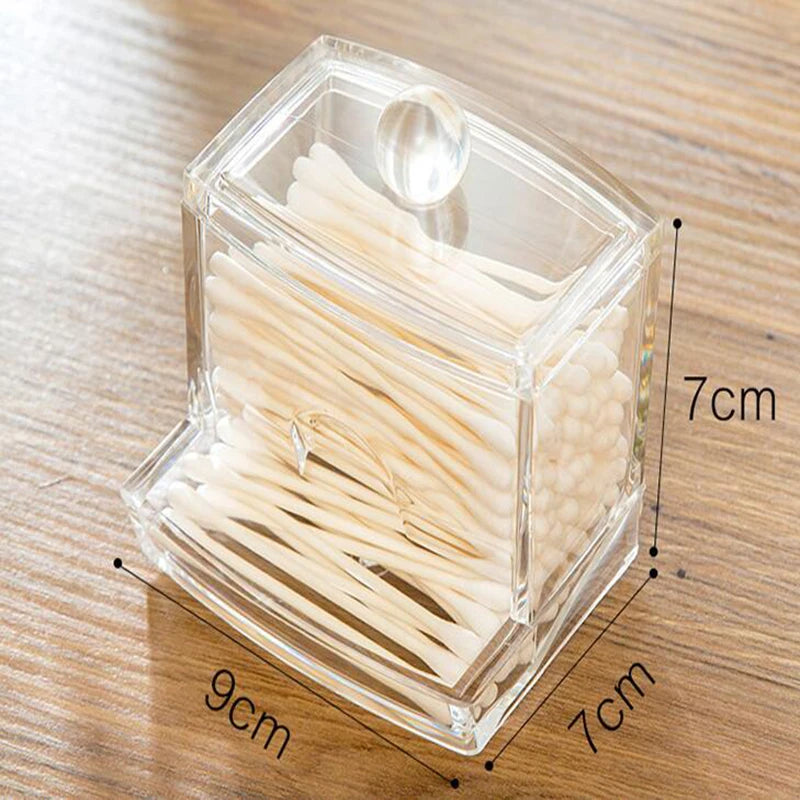 Clear acrylic cotton swab storage box with rounded knob lid and compact design on wooden surface