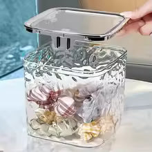 Clear acrylic hair accessories organizer storage box with a hinged lid holding colorful hair clips