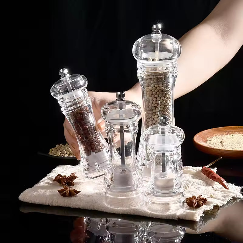 Acrylic manual paper grinder salt and pepper mills set filled with spices on white cloth