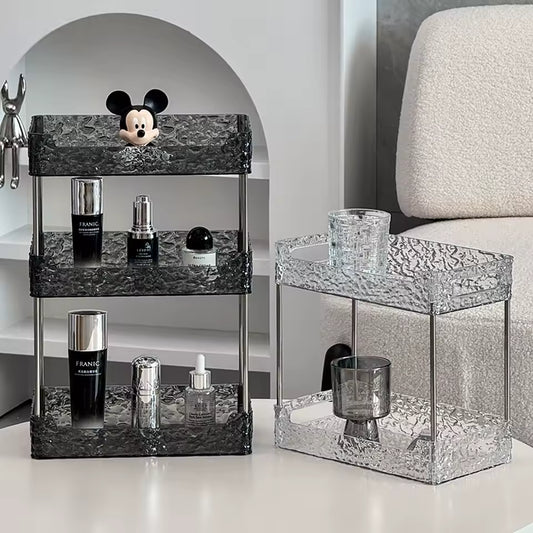 Black and clear acrylic shower organizer racks with three and two tiers holding bottles and accessories