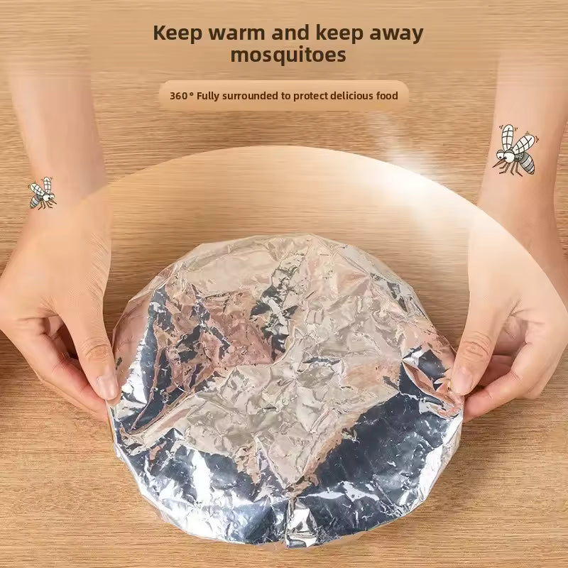 Hands holding aluminum foil pack for meal prep to keep food warm and protect from mosquitoes