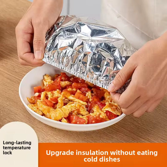 Hands covering a bowl of cooked food with aluminum foil pack for meal prep to keep it insulated