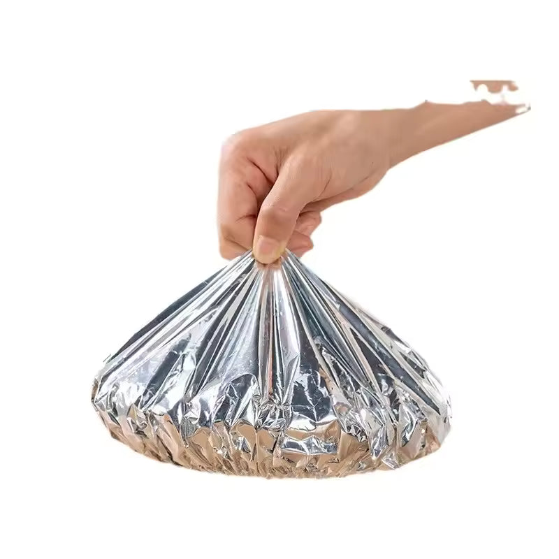 Hand holding a wrapped meal using aluminum foil pack for meal prep from Clarify.pk