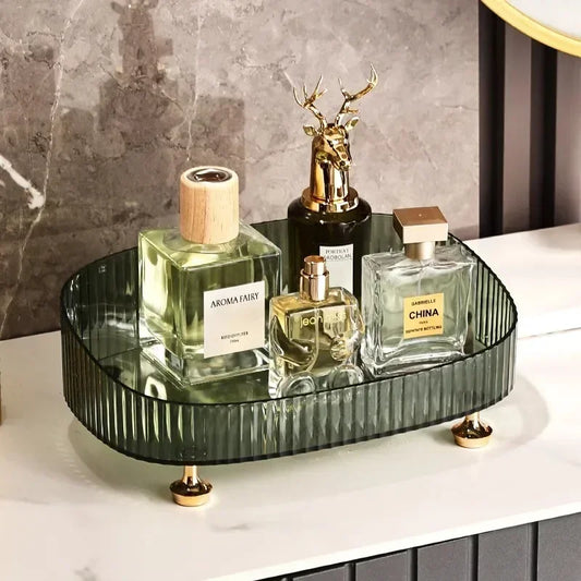 Transparent dresser storage box with ribbed design holding perfume bottles and decorative items