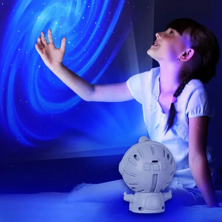 Girl enjoying blue galaxy projection from astronaut star projector lamp in a dark room