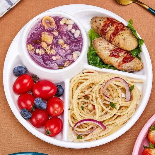 White 4 compartment plastic dinner plate with spaghetti cherry tomatoes blueberries chicken and purple pudding