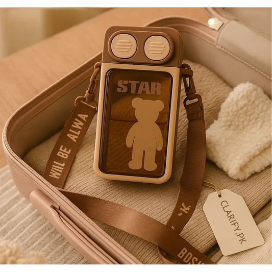 Bear themed water bottle with brown strap and cartoon bear design by Clarify.pk on beige fabric