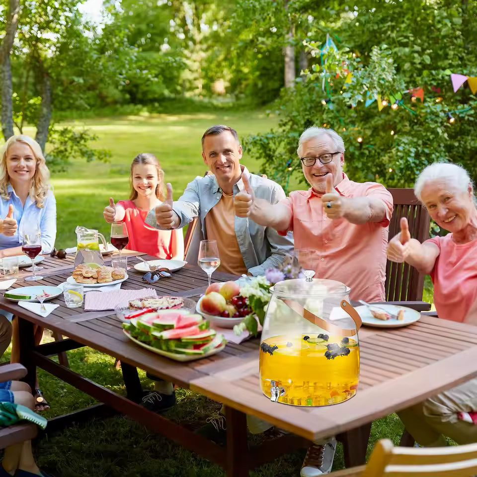 5.2L beverage dispenser with spigot filled with yellow drink on outdoor picnic table with family