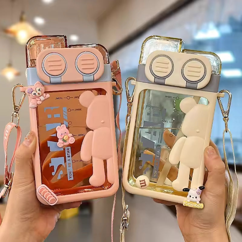 Cartoon bear water bottle with clear body and bear design in pink and beige colors held in hands