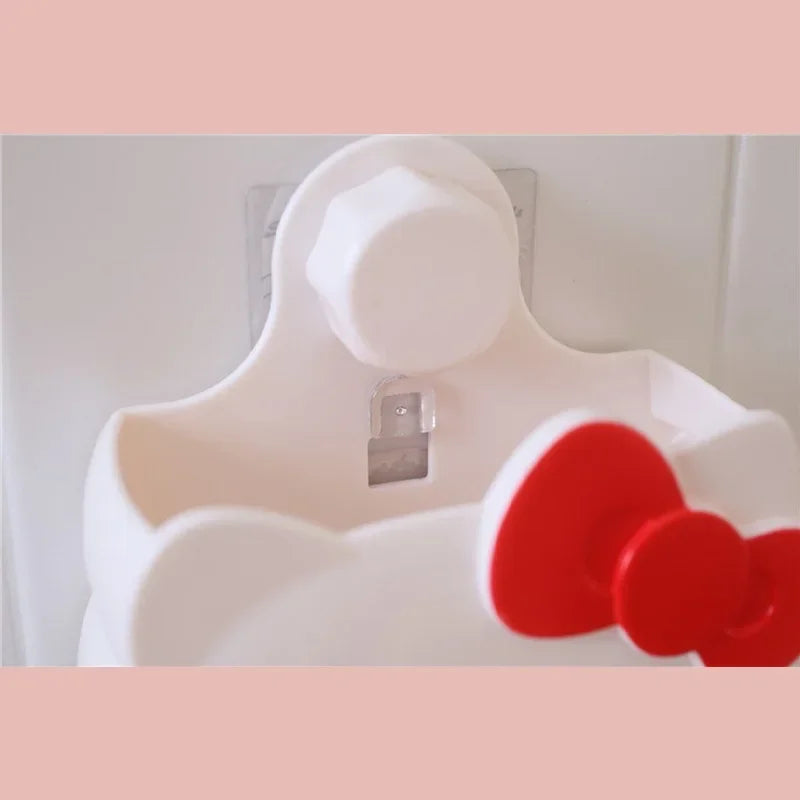 White cartoon bathroom organizer wall mount with red bow detail hanging on tiled wall