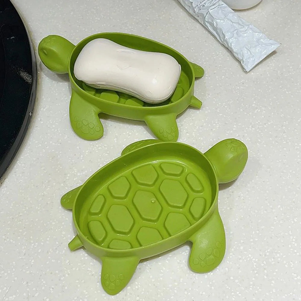 Green cartoon turtle soap holder with removable top and bar of white soap inside