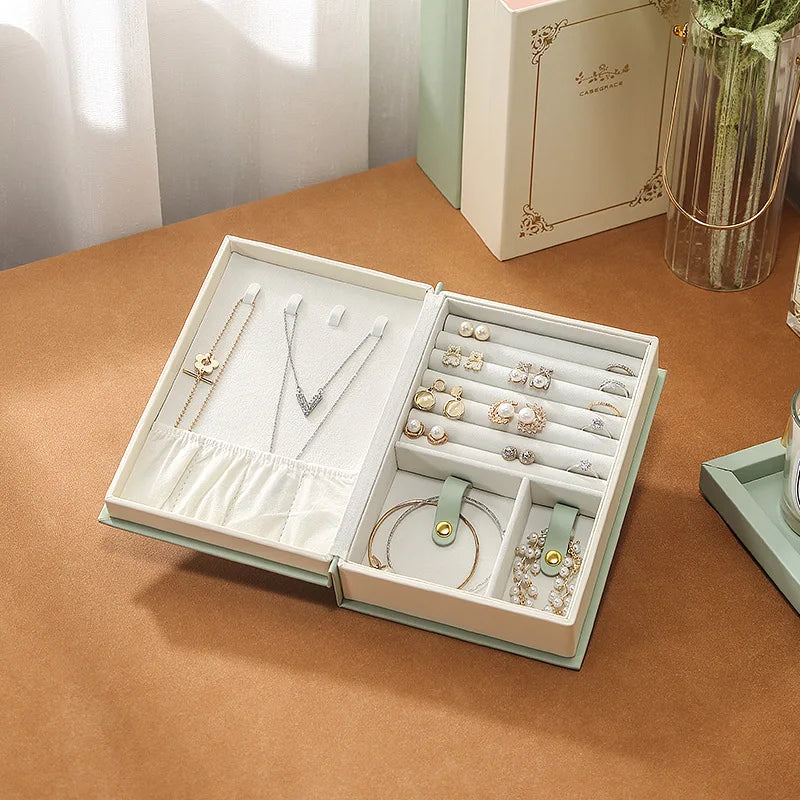 PU leather necklace and bracelet case opened to display organized jewelry including rings, earrings, and necklaces