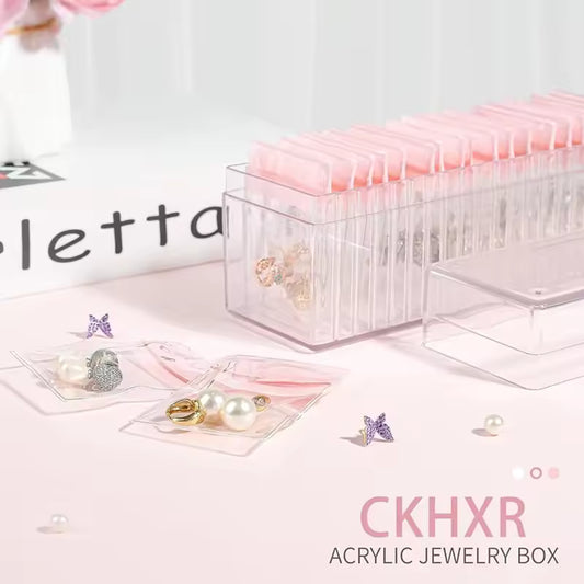 Clear acrylic jewelry box organizer with pink compartments for storing earrings and small jewelry