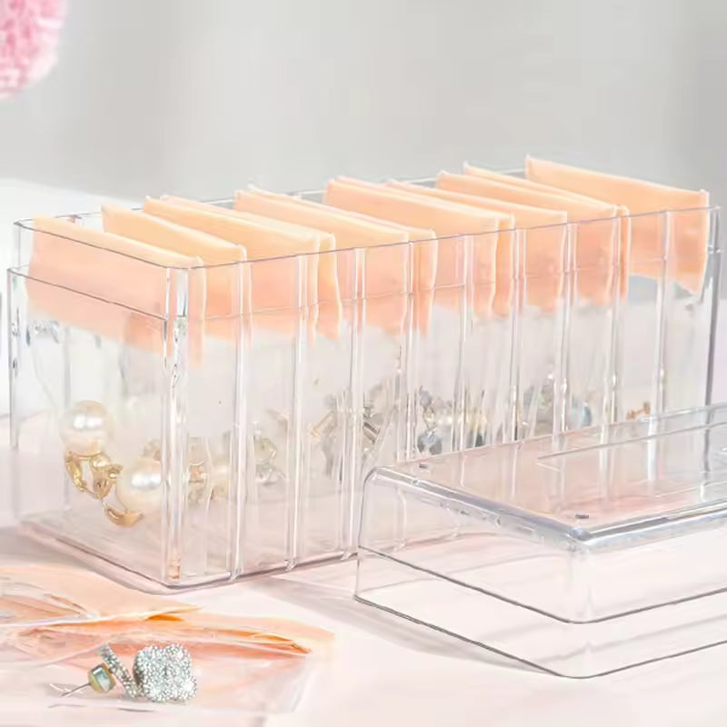 Clear acrylic jewelry organizer with multiple compartments and soft peach cushions for earrings