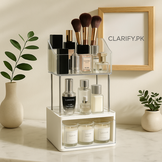 2-tier acrylic makeup organizer with clear tiers and white drawer on vanity holding brushes, perfumes, and candles