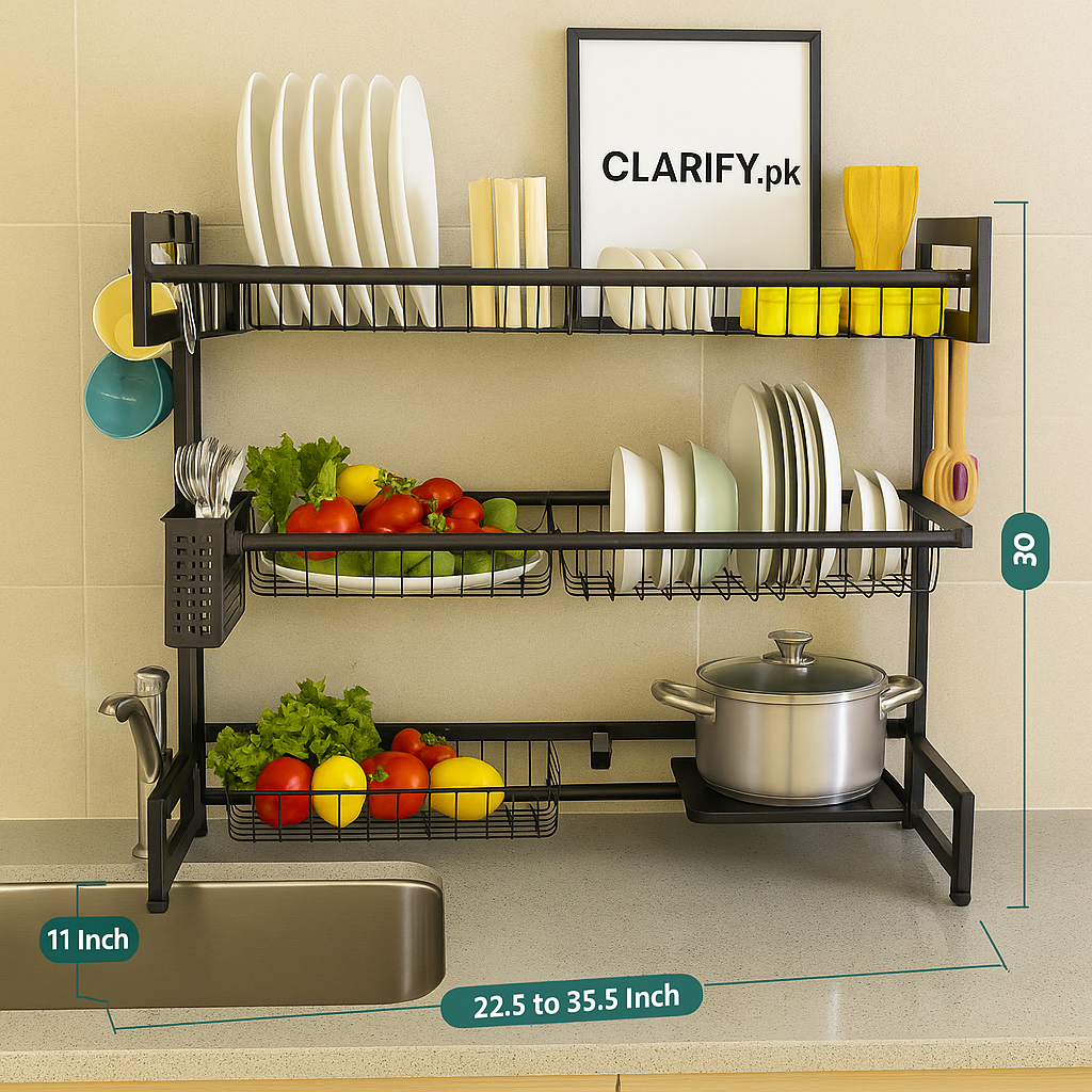 Clarify.pk expandable 2 tier over the sink rack in black metal holding plates, utensils, vegetables, and a pot